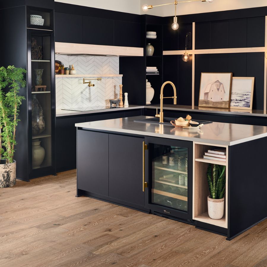 engineered hardwood flooring in modern kitchen with white subway tile, navy blue cabinets and gold accents